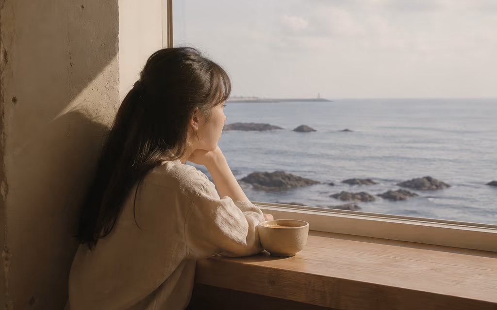애월 해안가 카페 창가에서 바다를 바라보는 손님
