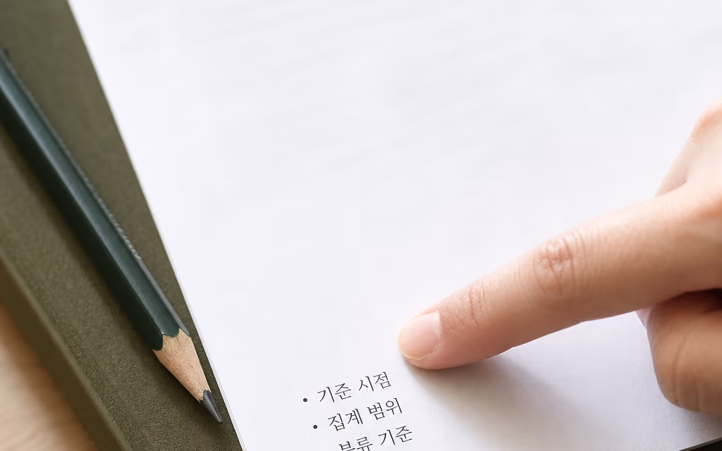출력한 통계표의 기준 항목을 손끝으로 짚는 모습