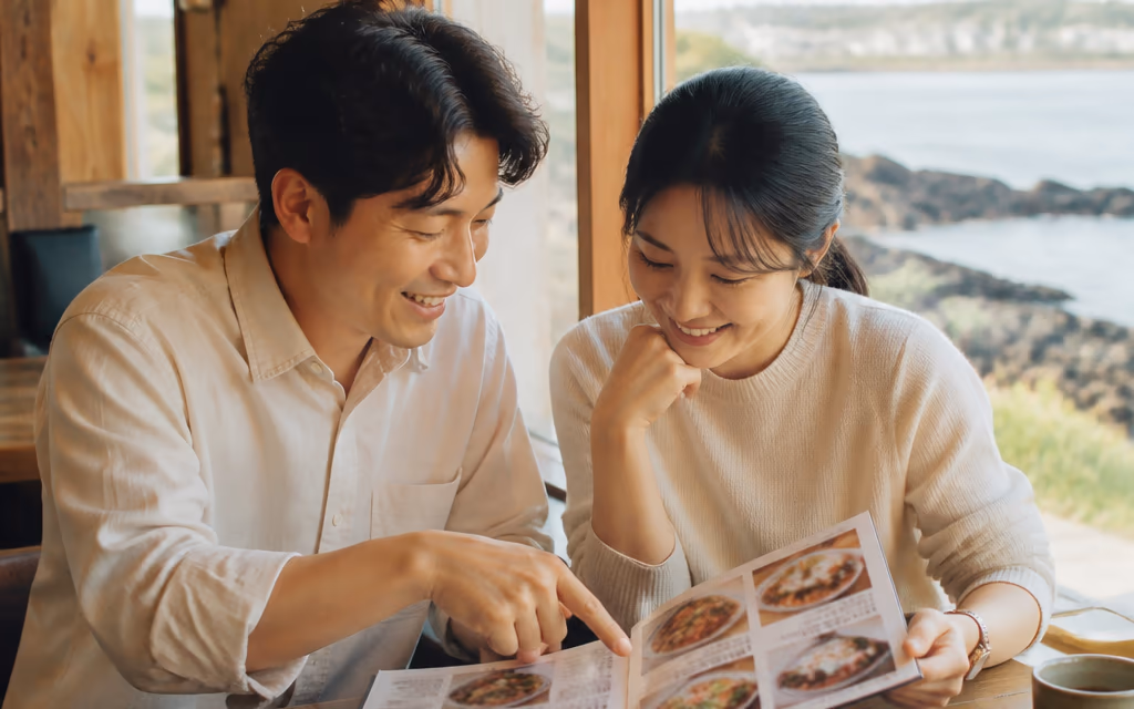 자리에 앉아 사진이 실린 메뉴판을 보며 음식을 고르는 손님들
