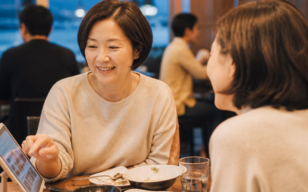 테이블 태블릿 메뉴판의 음식 사진을 보며 추가 주문을 고르는 손님