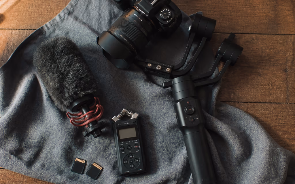 DSLR 옆 짐벌과 마이크가 함께 놓인 사진가 장비